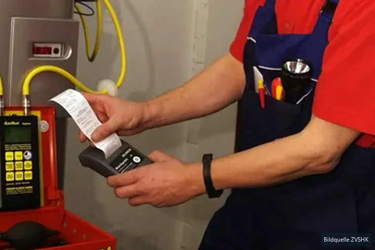 Messgerät mit ausgedrucktem Prüfprotokoll an der Gasleitung