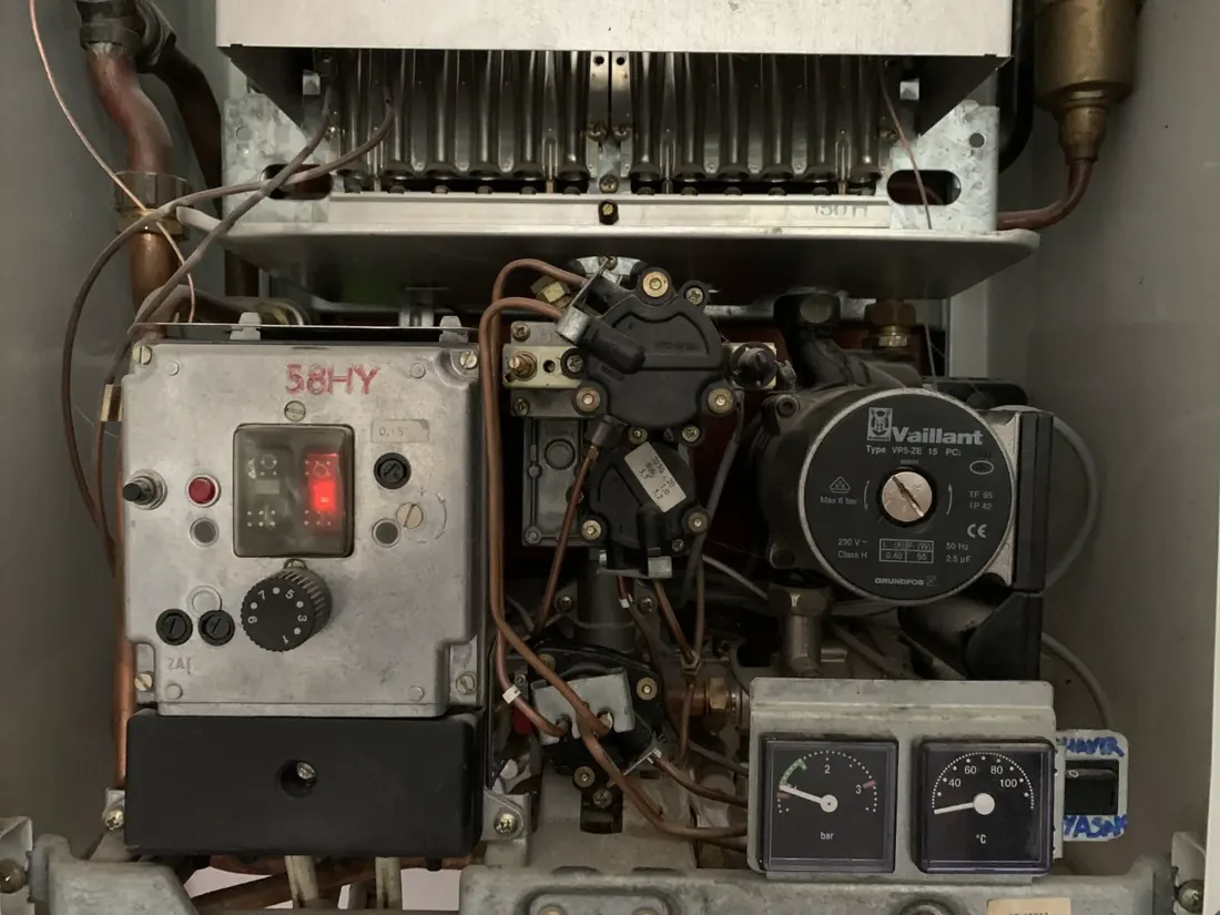 Geöffnete ältere Vaillant-Gastherme mit Brenner, Umwälzpumpe und Manometern